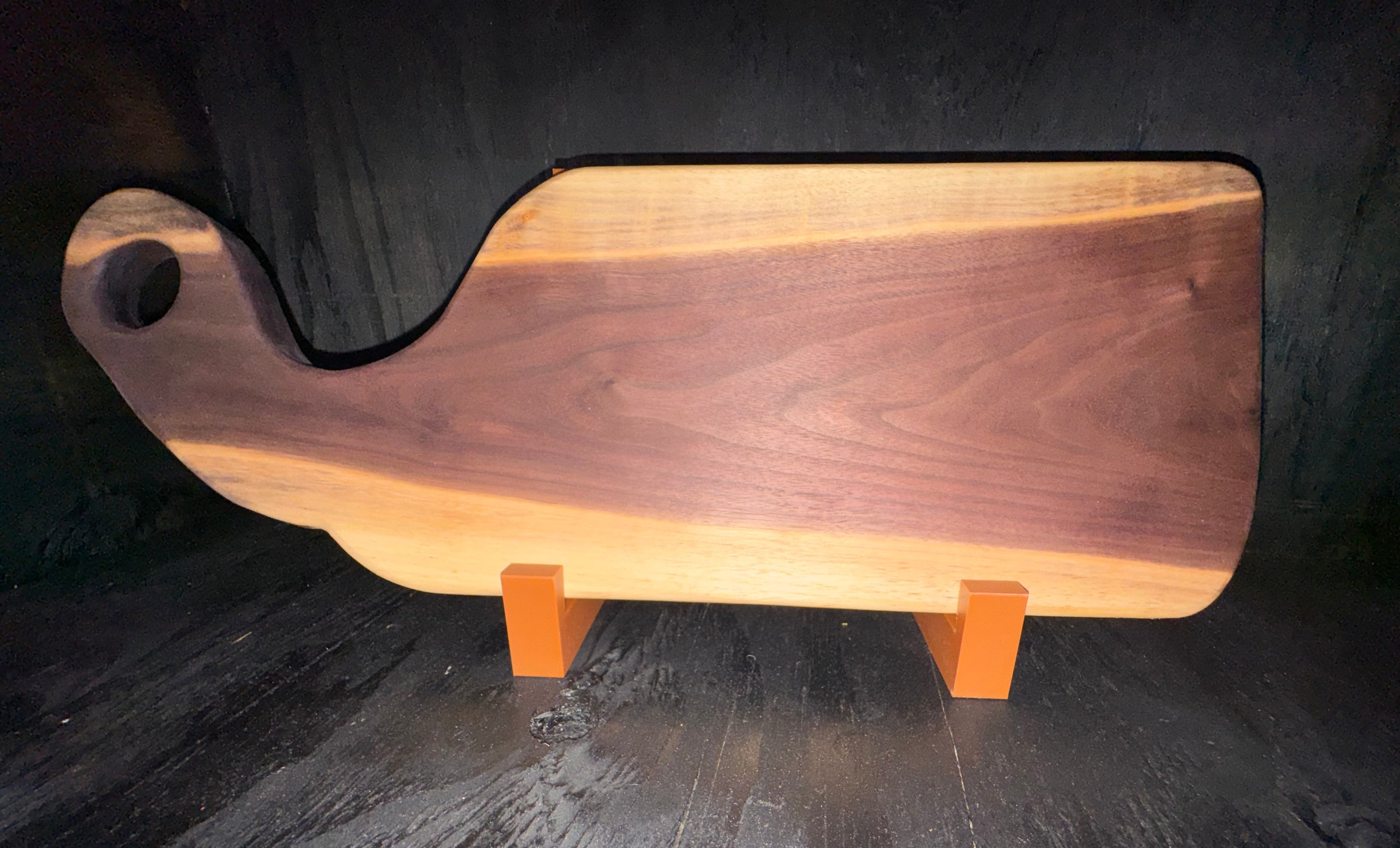 Handcrafted walnut serving board - edge detail on display stand