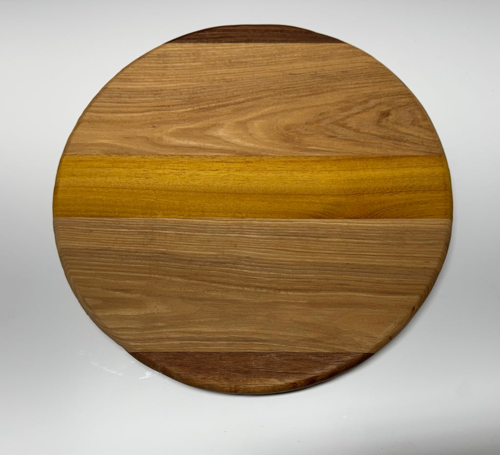 Round multi-species hardwood cutting board - top view showing walnut, oak, and osage orange grain