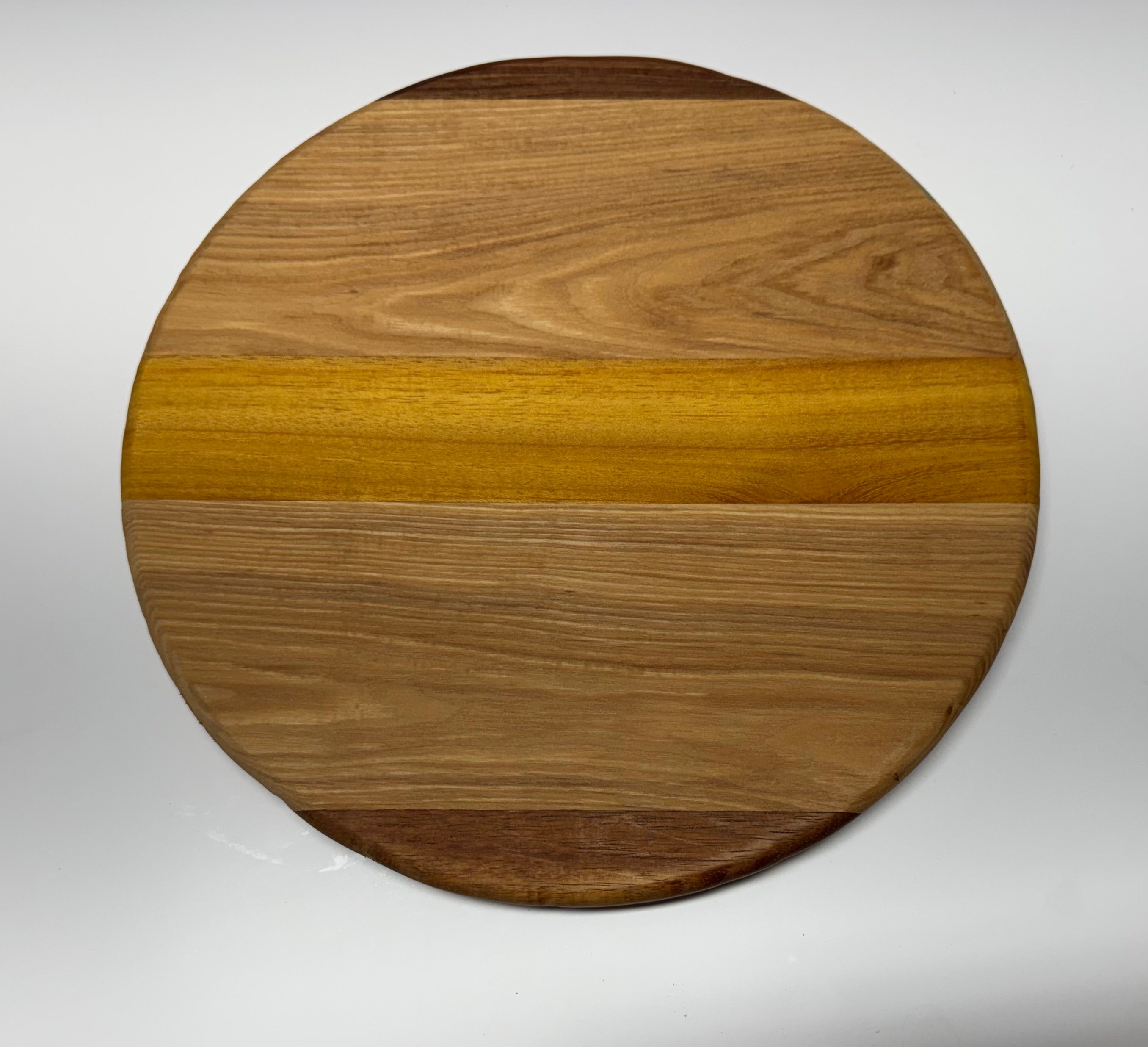 Round multi-species hardwood cutting board - top view showing walnut, oak, and osage orange grain