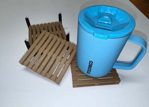 Two mini pallet coasters in brown and copper tones with black holder