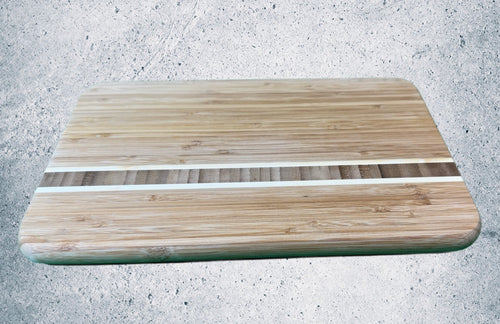 Bamboo cutting board with white resin stripe inlay, side angle view