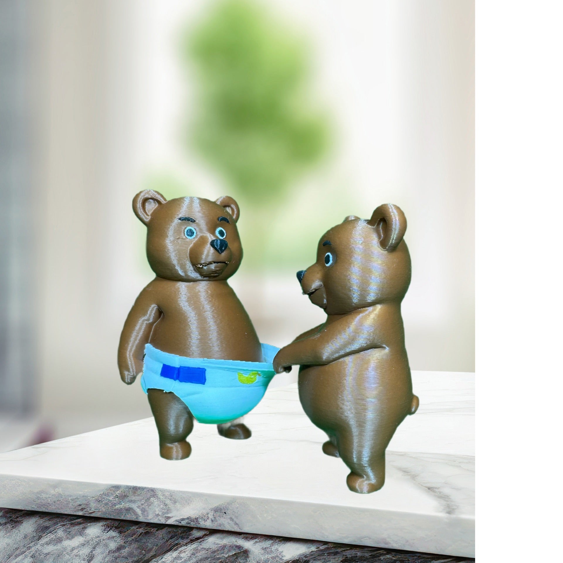 Back view of two 3D printed brown bear figurines, one pulling the other's blue diaper