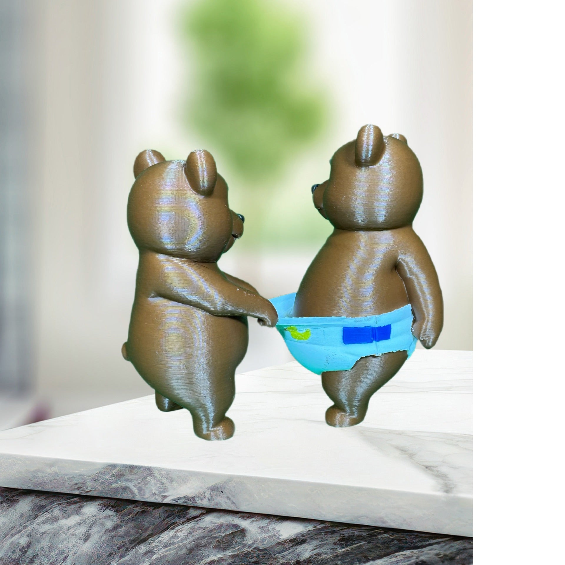 Front view of two 3D printed brown bear figurines with expressive blue eyes and diaper detail