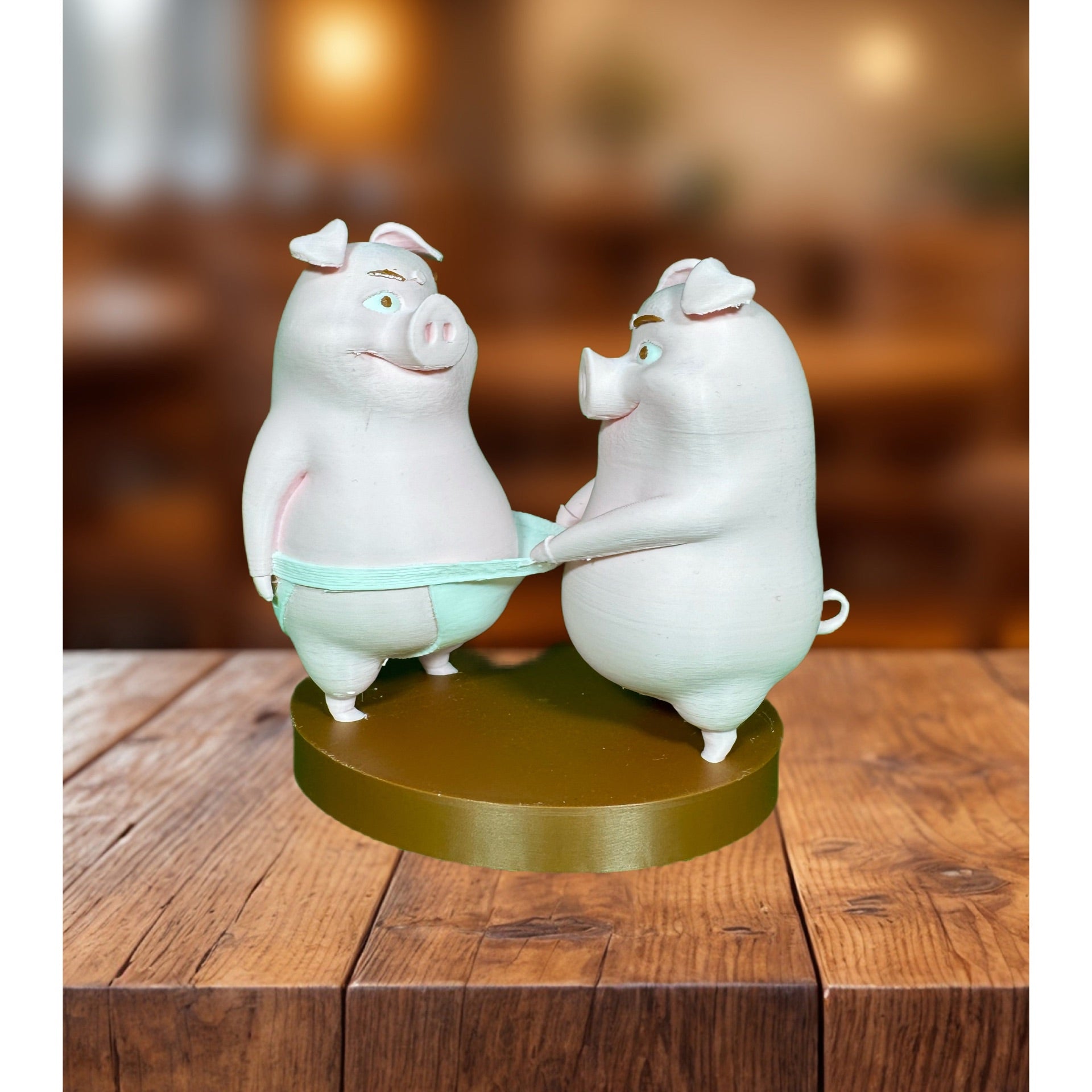 Rear view of two 3D printed pig figurines on a gold circular base showing back detail
