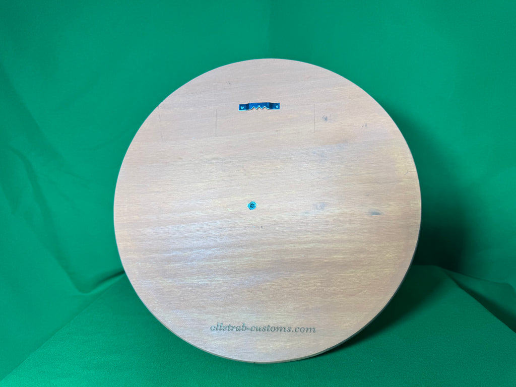 Back of wooden round backplate showing sawtooth hanger and Olletrab Customs branding