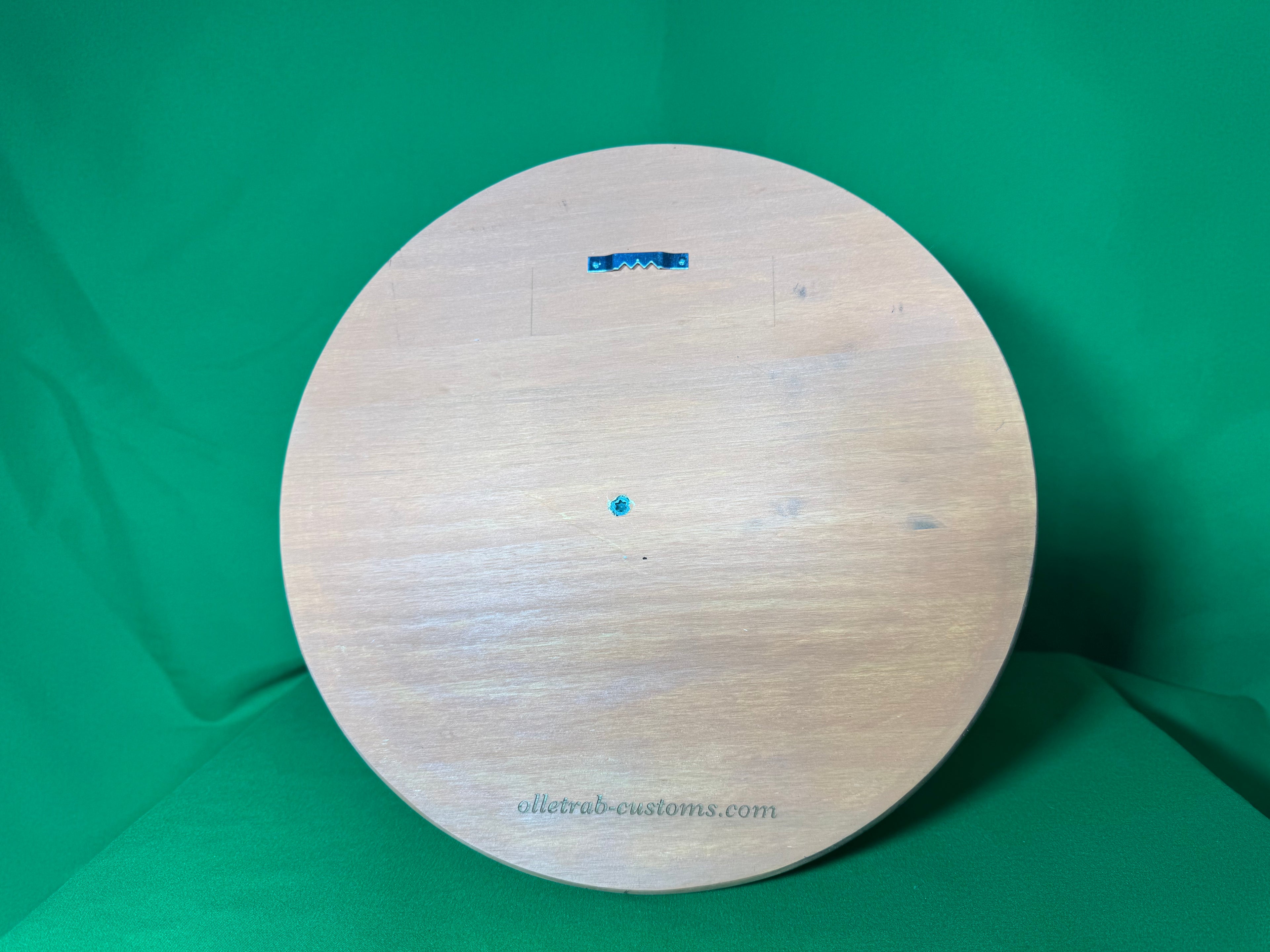 Back of wooden round backplate showing sawtooth hanger and Olletrab Customs branding