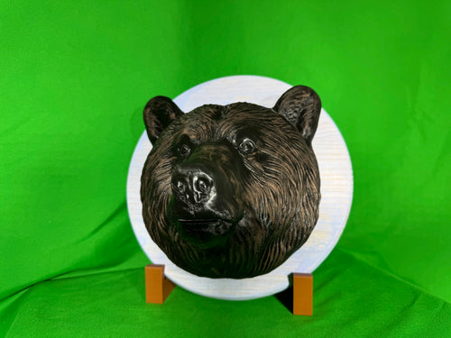 3D printed bear head wall hanging on white wooden round backplate, front view